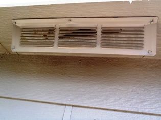 Image looking through a soffit vent to see a very small hole.